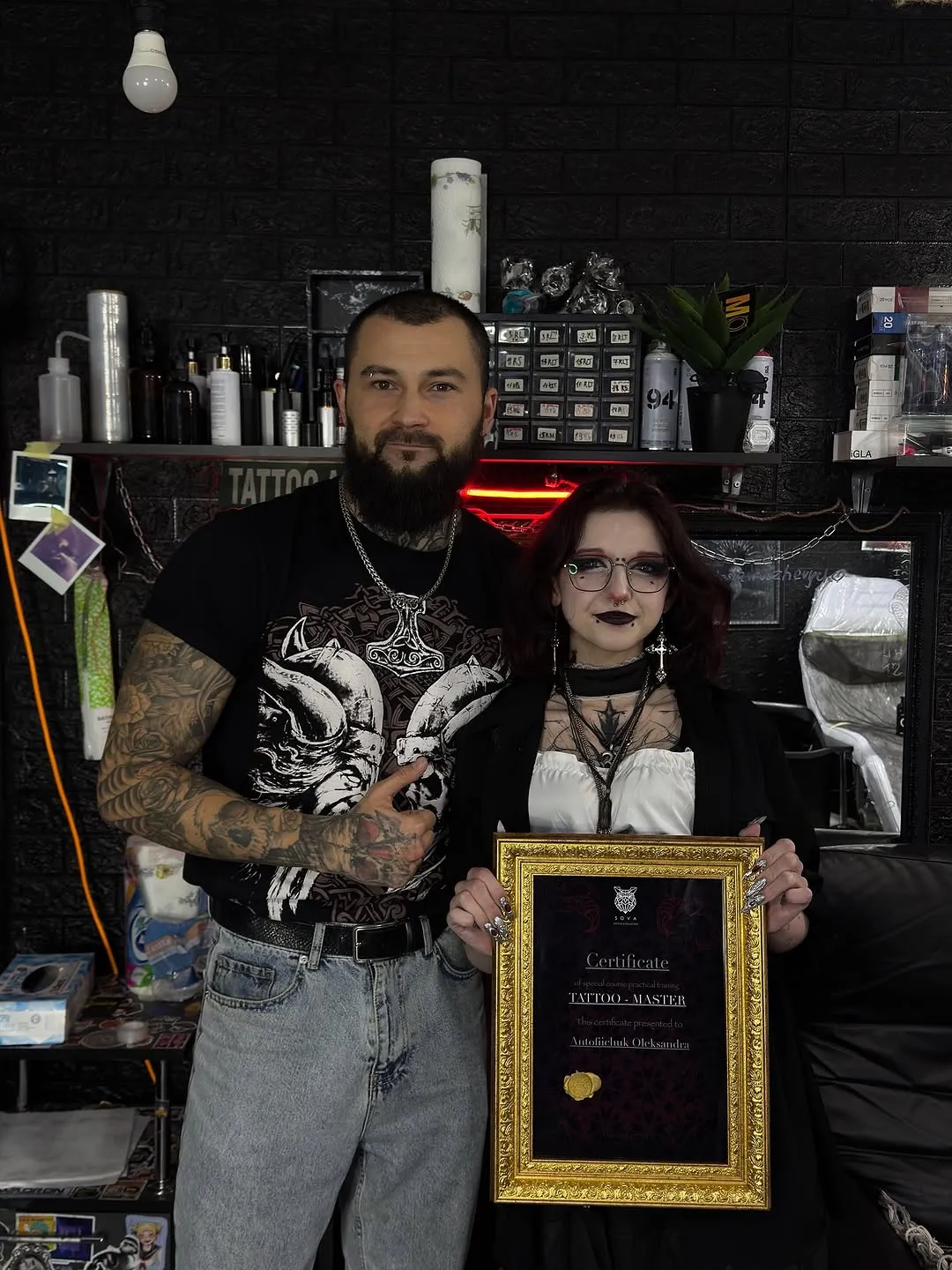 Чоловік і майстриня із сертифікатом у тату-студії